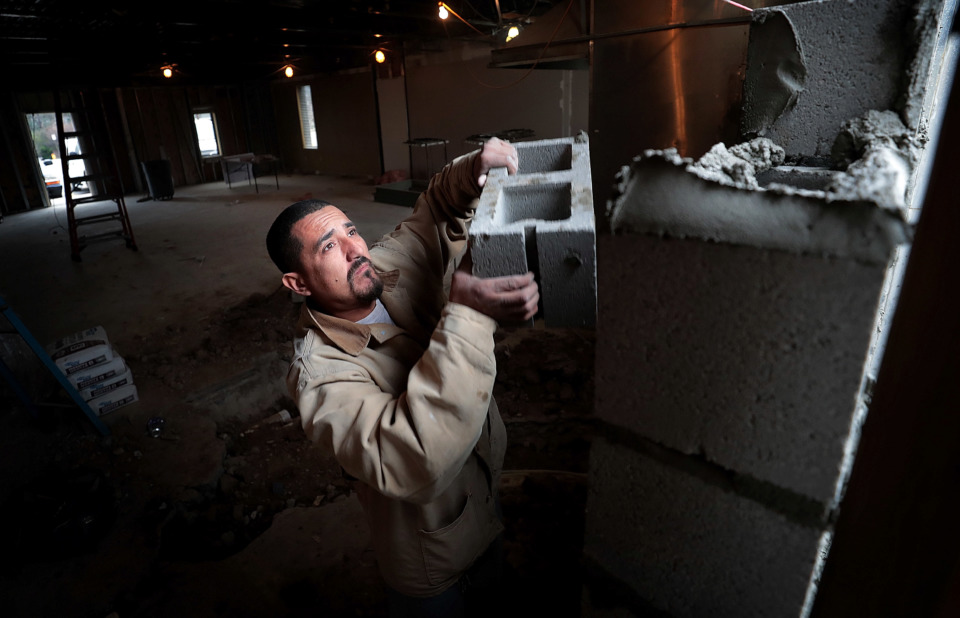 <strong>Antonio Mendez blocks up a rear entrance to the former Corky's corporate office as workers demolish the interior of the building on Dec. 19, 2018, which the East Memphis barbecue restaurant is renovating as an event center.</strong> (Jim Weber/Daily Memphian)