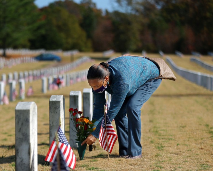 <strong>Carolyn Taylor places flowers on the grave of her brother Rodney Taylor, who was a Navy Veteran, on Veterans Day at the West Tennessee State Veterans Cemetery Nov. 11, 2020.</strong> (Patrick Lantrip/Daily Memphian)