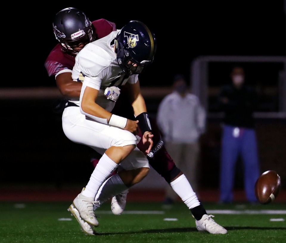 <strong>Arlington quarterback Zach Baker (15) gets the ball knocked out of his hands by a Collierville defender during a Nov. 13, 2020, road game.</strong> (Patrick Lantrip/Daily Memphian)