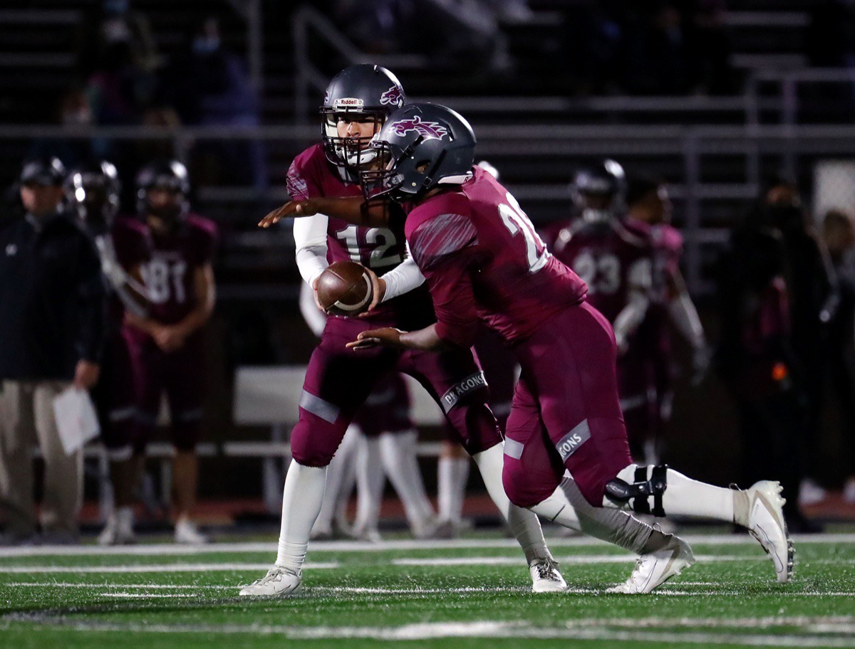 <strong>Collierville quarterback Ethan Pettigrew (12) hands the ball off to running back Troy Martin (29) during the Nov. 13, 2020, home game against Arlington.</strong> (Patrick Lantrip/Daily Memphian)