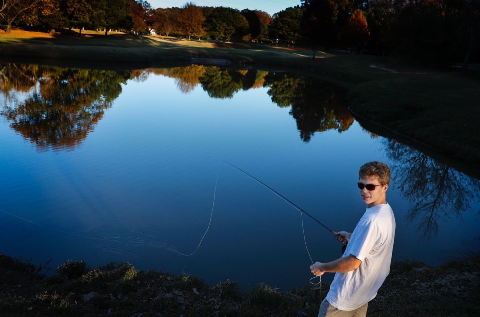 <strong>Trees with their leaves changing are reflected on a water hazard as University of Memphis student Jackson Swoap fishes on the 4th hole at The Links of Galloway on Thursday, Nov. 12, 2020</strong>. (Mark Weber/The Daily Memphian)