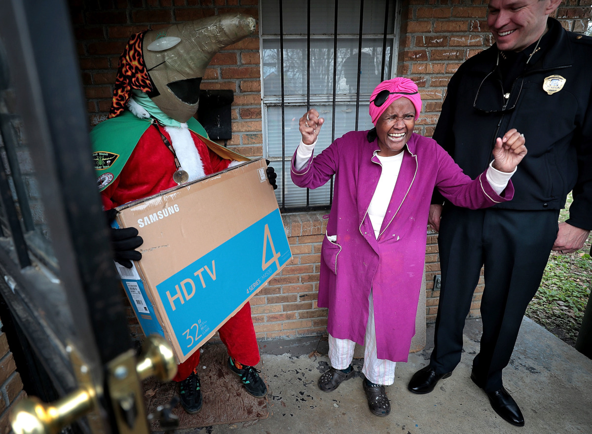 <strong>Burglary victim Sylvia Crump cheers for her new TV as she thanks the Memphis Police Department officers and Boll Weevils who showed up on her doorstep on Wednesday, Dec. 19, to replace Christmas gifts that were stolen from her house. MPD and the Weevils partnered with Target to make surprise deliveries to more than a dozen households that were recently burglarized.</strong> (Jim Weber/Daily Memphian)
