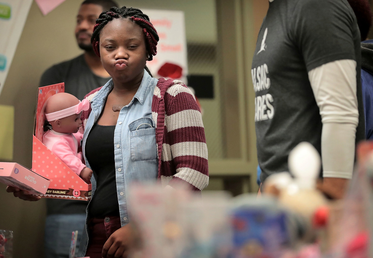 <strong>Tatyana Bellamy tries to make a tough toy choice while shopping for her 2-year-old during the Neighborhood Christian Center's annual Christmas toy store on Thursday, Dec. 20. The event provides more than 500 families with the opportunity to choose gifts for their children.</strong> (Jim Weber/Daily Memphian)