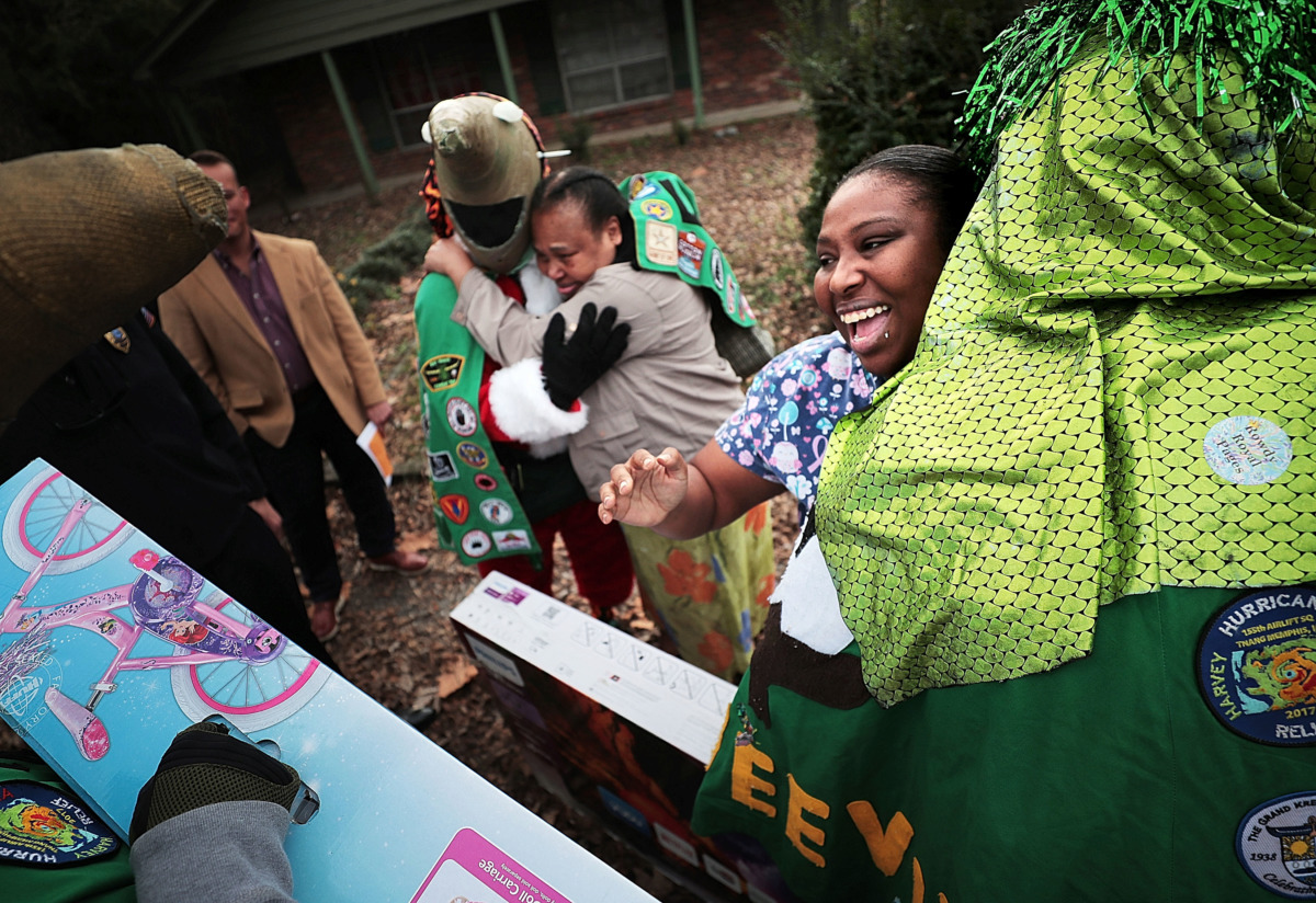 <strong>Burglary victim Monica Lawrence (right) and her mother, Shirley McGhee, thank Memphis Police officers and Boll Weevils who delivered items on Wednesday, Dec. 19, to replace Christmas gifts that were stolen from their home.</strong> (Jim Weber/Daily Memphian)
