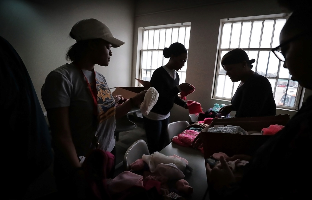 <strong>Youths with the Memphis Ambassadors Program and their parents sort through winter wear on Dec. 19, 2018 that was collected during MAP's charity coat drive. MAP kids collected more than 1,200 clothing items to distribute to needy children at Memphis community centers, Meritan foster care and area schools.</strong> (Jim Weber/Daily Memphian)