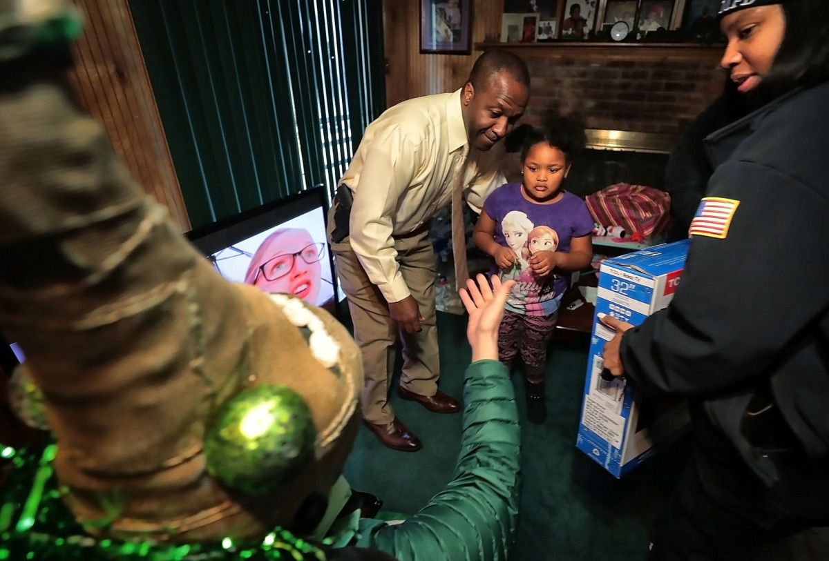 <strong>Burglary victim Terri Hanna Nixon, 5, shies away from one of the strangely dressed Boll Weevils who delivered gifts to her family on Wednesday, Dec. 19. MPD officers and the Weevils surprised more than a dozen households that were burglarized recently.</strong> (Jim Weber/Daily Memphian)