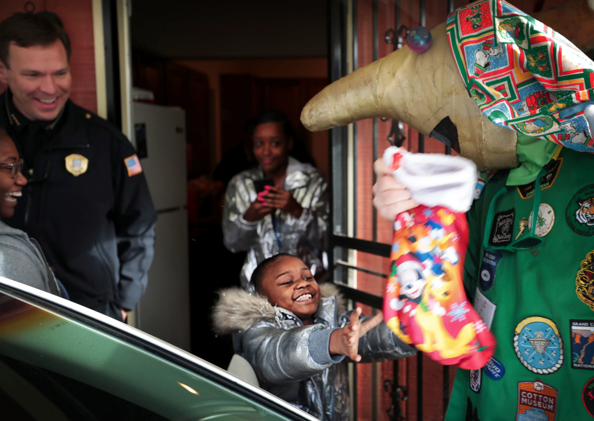<strong>Burglary victim Paris Patrick, 8, gets a new Christmas stocking full of gifts from a Boll Weevil who dropped off Christmas gifts to replace items that were stolen from the family's home.</strong>&nbsp;(Jim Weber/Daily Memphian)