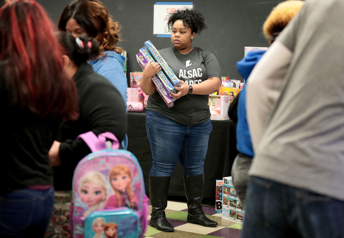 <strong>Volunteer Jarmeese Morrow helps shoppers during the Neighborhood Christian Center's annual Christmas toy store on Thursday, Dec. 20. The NCC provided more than 500 families with the opportunity to choose presents for their children.</strong> (Jim Weber/Daily Memphian)
