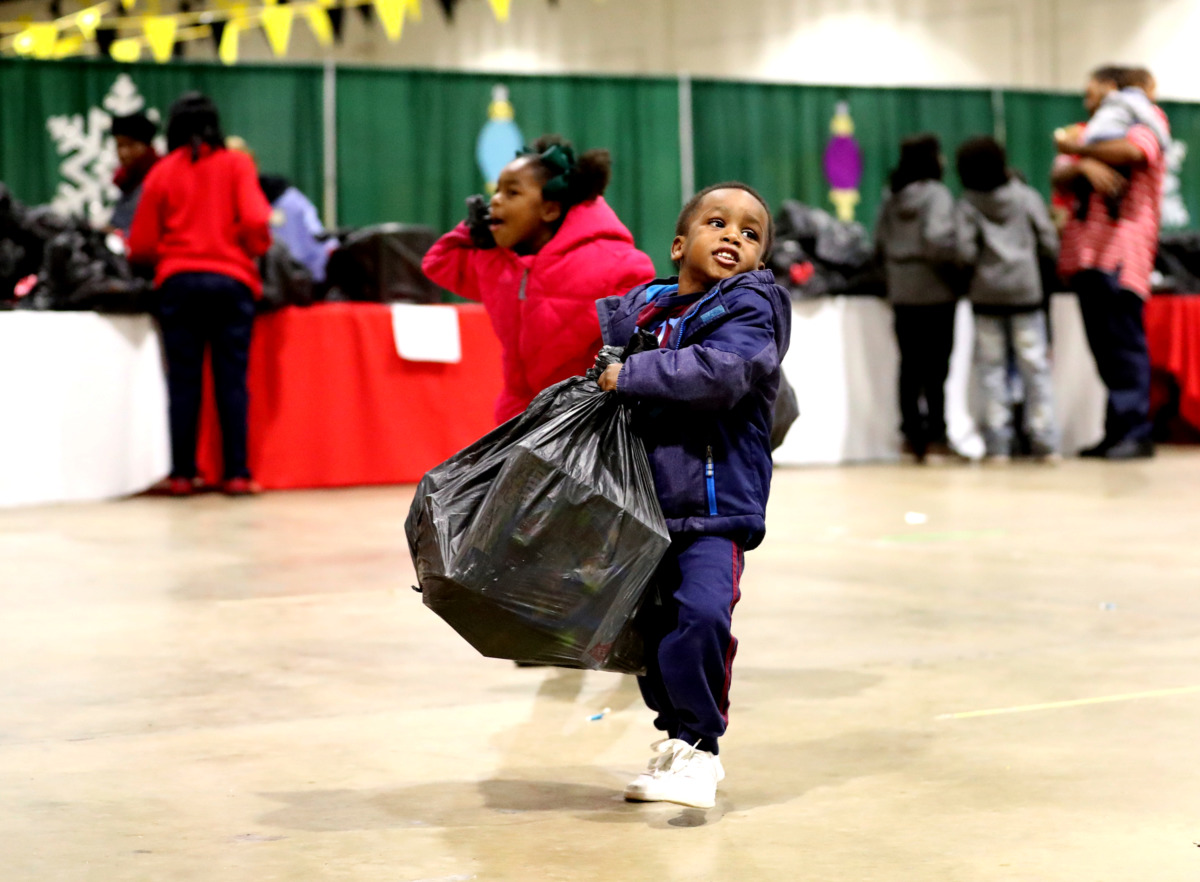 <strong>Zion Banks, 3, lifts a heavy bag of toys he picked up from the "Tiger Toy Drive" hosted by the University of Memphis men's basketball team and the City of Memphis.</strong> (Houston Cofield/Daily Memphian)