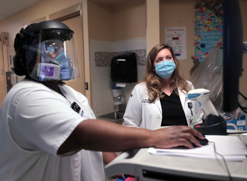 <strong>Dr. Amber Thacker (right) and Trishonda Scurlock go over patient data in a Regional One COVID ward in September.</strong> (Patrick Lantirp/Daily Memphian file)