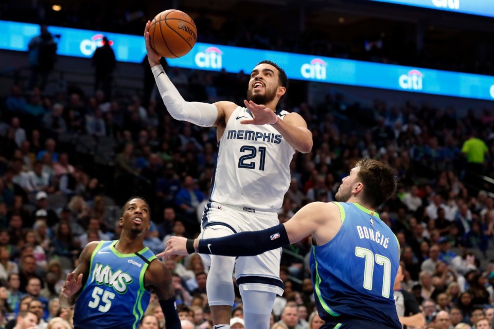 <strong>Memphis Grizzlies guard Tyus Jones split Dallas Mavericks guards Delon Wright and Luka Doncic on his way to the basket in March</strong>&nbsp;(AP file Photo/Ray Carlin)
