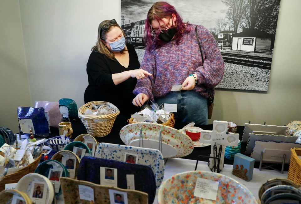 <strong>Beth Chancey and daughter Ruth look over items in Shepherd's Haven popup shop at Groome &amp; Co. Realtors LLC office on Dec. 14, 2020, in Arlington. </strong>(Mark Weber/The Daily Memphian)