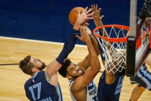 <strong>Minnesota Timberwolves center Karl-Anthony Towns (32) drives to the basket between Memphis Grizzlies center Jonas Valanciunas (17) and guard Ja Morant (12) in the first quarter of a preseason NBA basketball game Monday, Dec. 14, 2020, in Minneapolis.</strong> (Bruce Kluckhohn/AP)