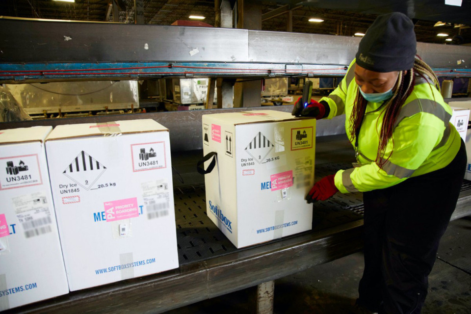 <strong>A package handler at the FedEx Express world hub in Memphis adjusts a box of Pfizer/BioNTech&rsquo;s COVID-19 vaccine during sorting Dec. 13. The Tennessee Department of Health received an early shipment Monday but expects to deliver 56,550 doses to hospitals on Thursday.</strong> (Courtesy FedEx)