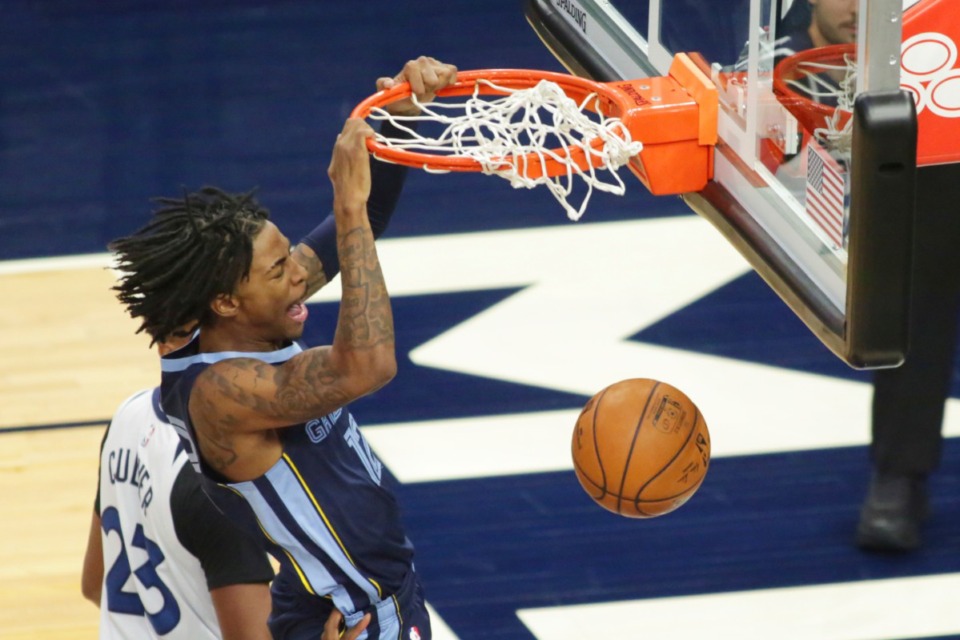 <strong>Memphis Grizzlies guard Ja Morant dunks in front of a Minnesota Timberwolves defender during their game on Saturday, Dec. 12, in Minneapolis.</strong> (Andy Clayton-King/Associated Press)