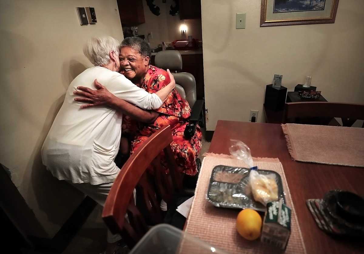 <strong>MIFA volunteer Cookie Ewing gives Hannah Mason a parting hug after delivering a MIFA meal to her Binghampton apartment. Fueled by thousands of volunteers, MIFA, which turns 50 this year, has gone high tech with pre-plotted routes and an app, but deliveries are still made with a personal touch. (Jim Weber/Daily Memphian)</strong>