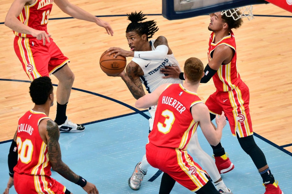 <strong>Memphis Grizzlies guard Ja Morant, center, handles the ball against Atlanta Hawks guards Kevin Huerter (3) and Trae Young, right, in the first half of an NBA preseason basketball game Saturday, Dec. 19, 2020, at FedExForum.</strong> (Brandon Dill/AP)
