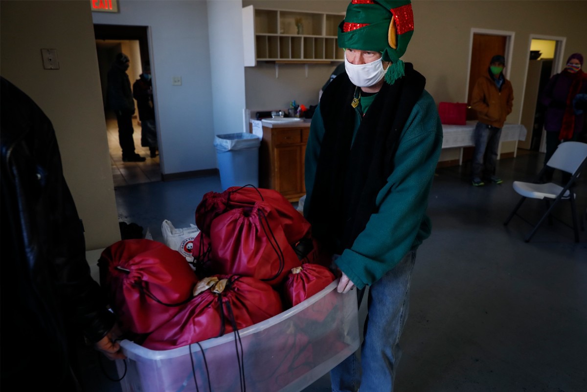 <strong>Lunches &rsquo;N Love outreach ministries&rsquo; volunteer Joe Morris wears a festive hat while carrying supplies to be handed out to the needy on Friday, Dec. 25, 2020.</strong> (Mark Weber/The Daily Memphian)