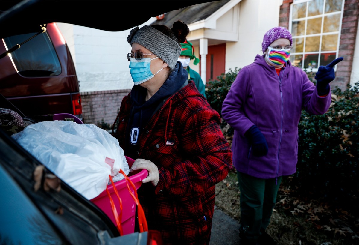 <strong>Lunches &rsquo;N Love outreach ministries&rsquo; volunteers Robin Gordon (left) and Lori Morris (right) load their cars with supplies that will be handed out to the needy on Friday, Dec. 25, 2020.</strong> (Mark Weber/The Daily Memphian)