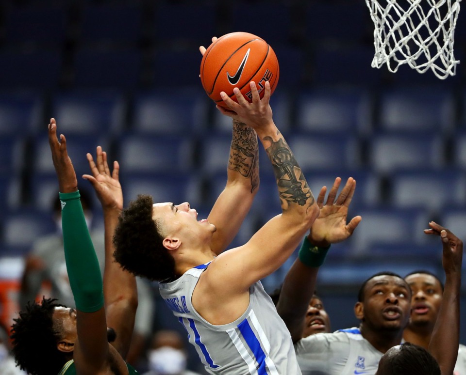 <strong>University of Memphis guard Lester Quinones (11) fights through a foul during a home game against the University of South Florida Dec. 29, 2020.&nbsp;Quinones has been the team&rsquo;s most consistent player.</strong> (Patrick Lantrip/Daily Memphian)