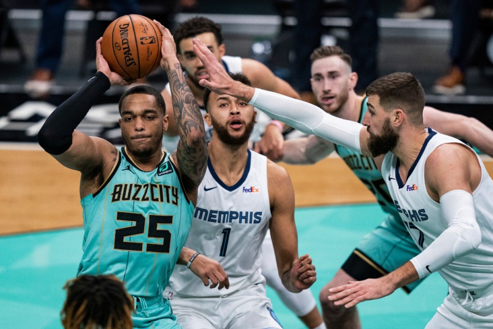 <strong>Charlotte Hornets forward P.J. Washington (25) looks to pass the ball while being defended by Memphis Grizzlies forward Kyle Anderson (1) and center Jonas Valanciunas during the first half of an NBA basketball game in Charlotte, N.C., Friday, Jan. 1, 2021.</strong> (AP Photo/Jacob Kupferman)