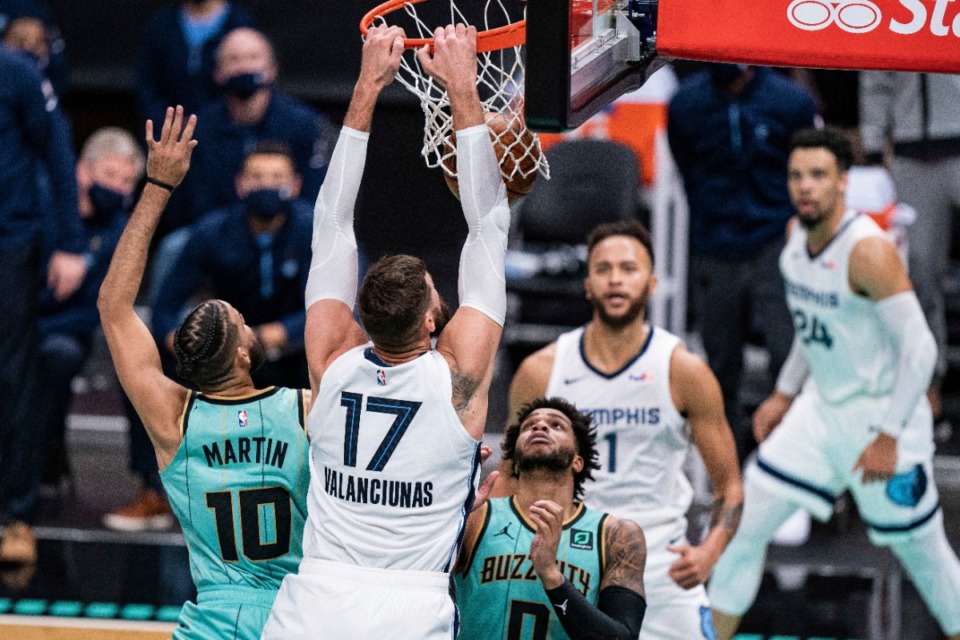<strong>Memphis Grizzlies center Jonas Valanciunas (17) dunks over Charlotte Hornets forward Caleb Martin (10) and forward Miles Bridges (0) during the second half of an NBA basketball game in Charlotte, N.C., Friday, Jan. 1, 2021.</strong> (Jacob Kupferman/AP)