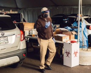 <strong>A health care worker ushers a line of vehicles through a coronavirus vaccination site on Dec. 28, 2020.</strong>&nbsp;<strong>As the demand to vaccinate health care and essential workers goes down there are a limited number of shots available for funeral workers and those age 75 and older.</strong>&nbsp;(Houston Cofield/Special To The Daily Memphian)