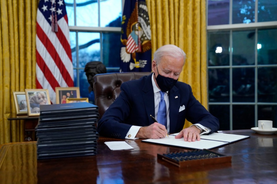 <strong>President Joe Biden signs executive orders in the Oval Office of the White House on Wednesday, Jan. 20, in Washington.</strong>&nbsp;(Evan Vucci/Associated Press)