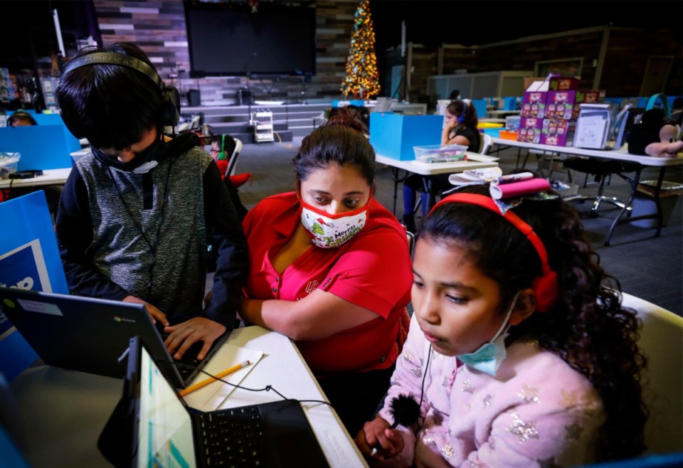 <strong>Education specialist Adriana Cortes (middle, in a file photo) works with fourth-grade students Stephen Escalante (left) and Zoe Centeno (right) while they attend virtual school at Las Americas.</strong> (Mark Weber/The Daily Memphian)