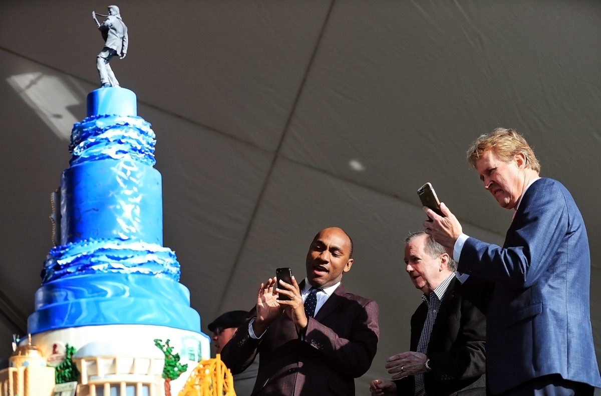<strong>Shelby County Mayor Lee Harris (left), EPE CEO Jack Soden and Kevin Kane of the Memphis Convention &amp; Visitors Bureau grab a couple quick shots of the cake as Elvis fans gather at Graceland on Jan. 8, 2019, to celebrate the King of Rock &rsquo;n&rsquo; Roll&rsquo;s 84th birthday.</strong> (Jim Weber/Daily Memphian)