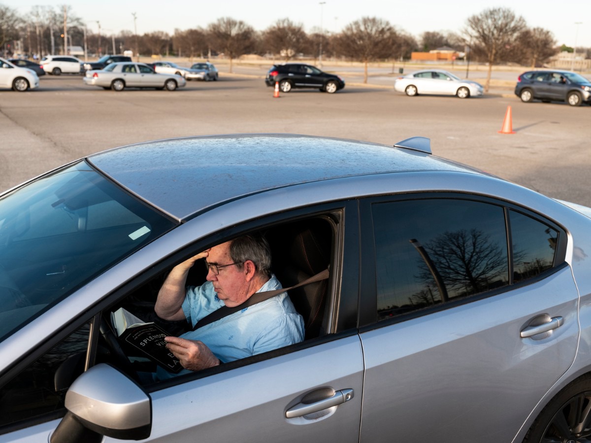 <strong>Bill Bayne, 77, reads a book while waiting in line to receive his COVID-19 vaccine inside the Pipkin Building, Friday, Jan. 29, 2021.</strong> (Brad Vest/Daily Memphian to The Daily Memphian)