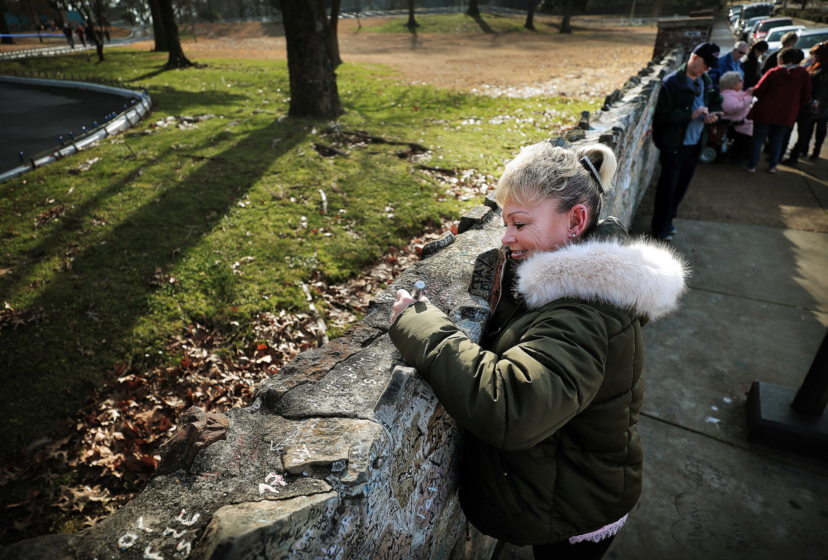 <strong>Debbie Davis from Bristol, England, signs the wall as Elvis fans gather at Graceland on Jan. 8, 2019, to celebrate the King of Rock &rsquo;n&rsquo; Roll&rsquo;s 84th birthday during the annual birthday proclamation and cake cutting ceremony on the front lawn.&nbsp;</strong> (Jim Weber/Daily Memphian)