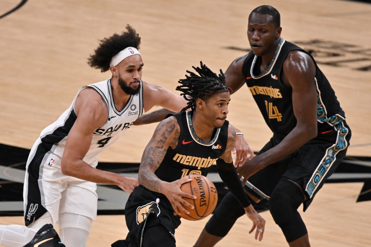 <strong>Memphis Grizzlies' Ja Morant, (center) drives past San Antonio Spurs' Derrick White (4) as Grizzlies' center Gorgui Dieng looks on during an NBA basketball game, Saturday, Jan. 30, 2021, in San Antonio.</strong> (Darren Abate/AP)