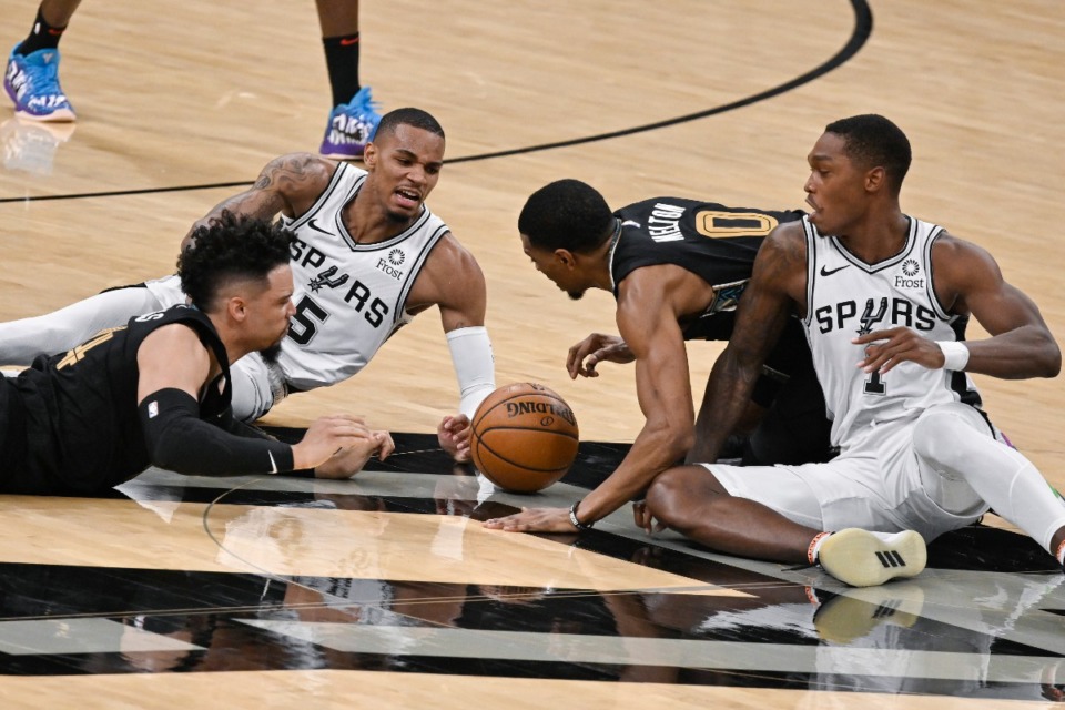 <strong>San Antonio Spurs' Dejounte Murray (5) and Lonnie Walker IV (right), scramble for the ball against Memphis Grizzlies' Dillon Brooks (left), and De'Anthony Melton during the second half of an NBA basketball game, Saturday, Jan. 30, 2021, in San Antonio.</strong> (Darren Abate/AP)