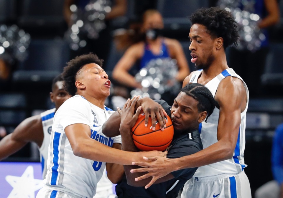 <strong>Tigers defenders Boogie Ellis (left) and DeAndre Williams (right) apply defensive pressure on UCF guard Darius Perry (middle).</strong> (Mark Weber/The Daily Memphian)