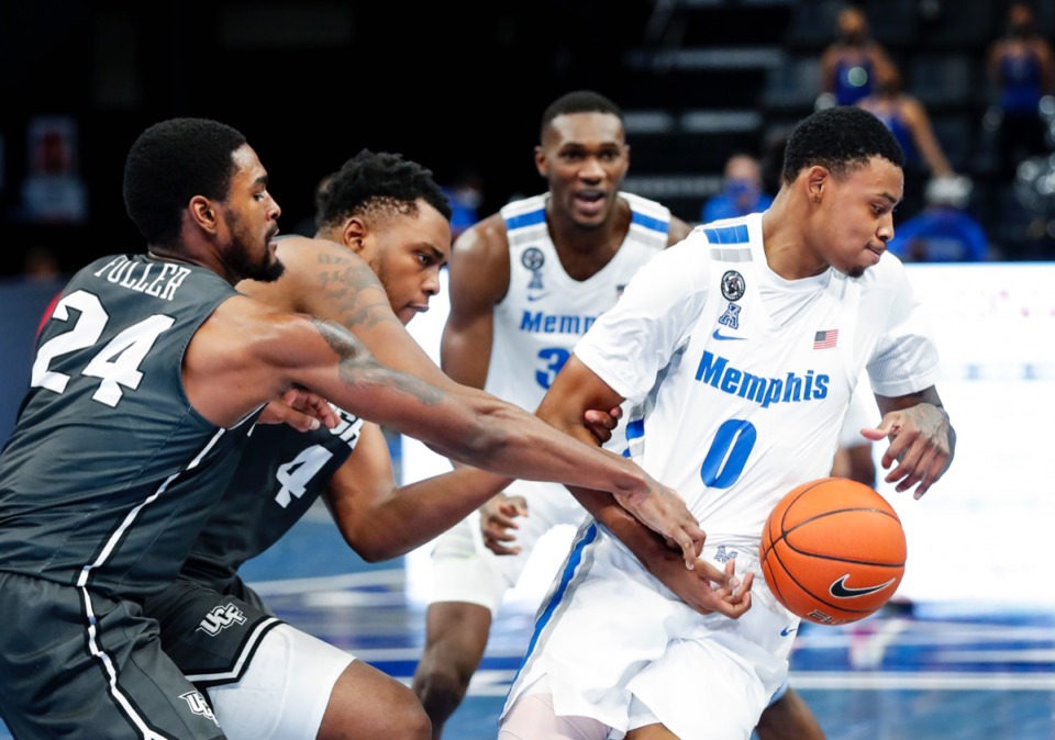 <strong>Tigers forward D.J. Jeffries (right) grabs a rebound from the UCF defenders Dre Fuller Jr. (left) and Jamille Reynolds (middle).</strong> (Mark Weber/The Daily Memphian)