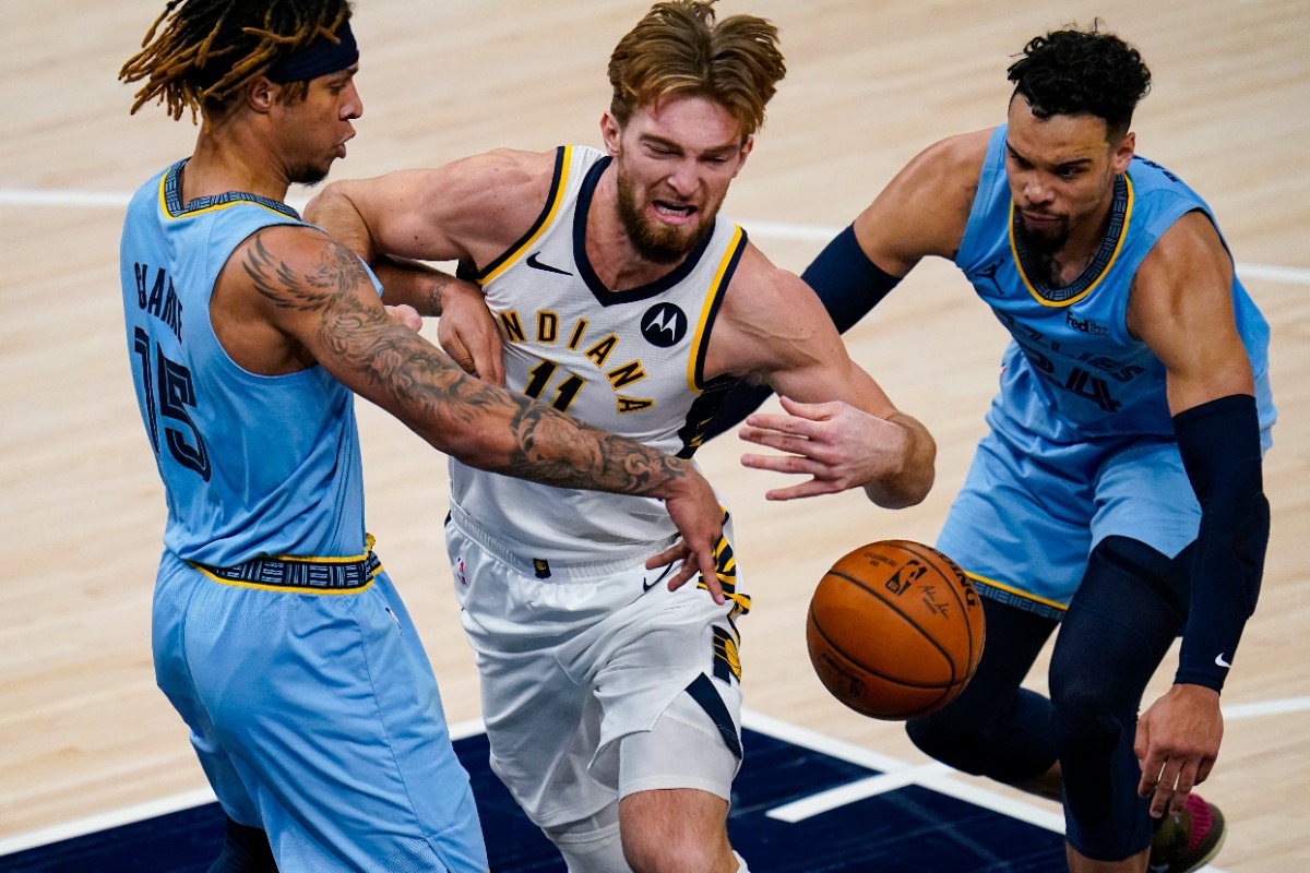 <strong>Indiana Pacers forward Domantas Sabonis (11) is fouled as he drives between Memphis Grizzlies forward Brandon Clarke (15) and guard Dillon Brooks (24) in Indianapolis, Tuesday, Feb. 2, 2021.</strong> (Michael Conroy/AP)
