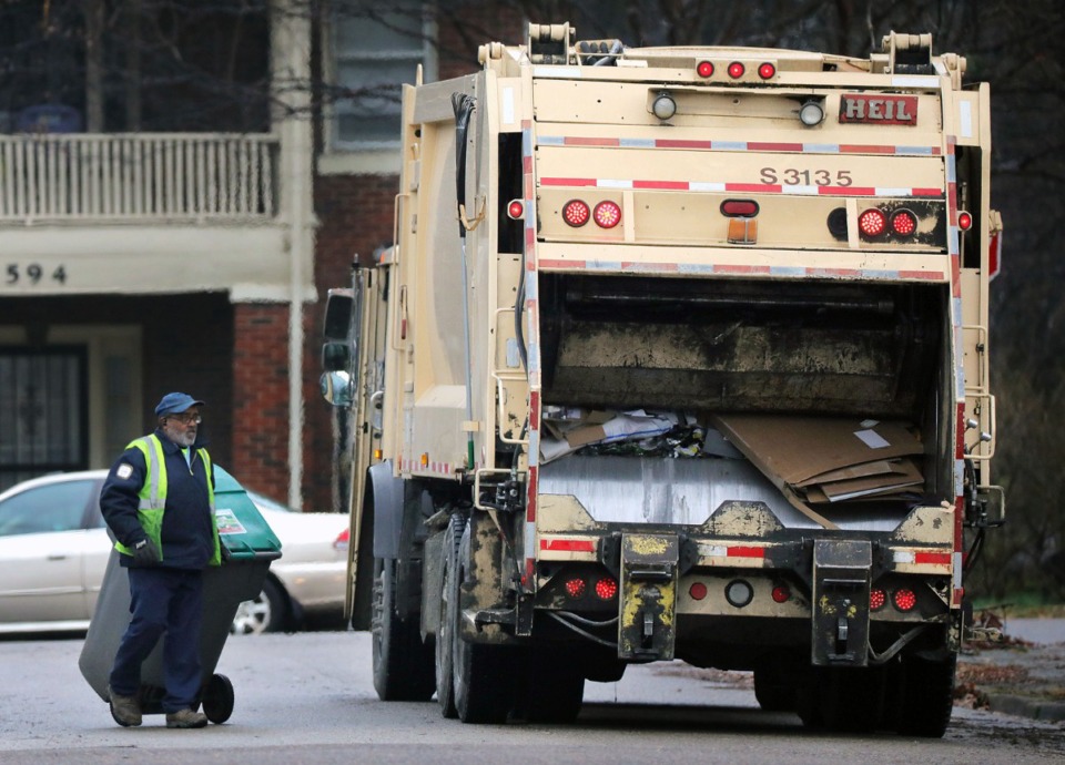 <strong>A sanitation worker hauls a garbage can to his truck in the Evergreen neighborhood of Midtown, Memphis Jan. 31, 2020. Solid waste pickup days will change for some residents in parts of Hickory Hill and Cordova effective March 1.</strong> (Patrick Lantrip/Daily Memphian file)
