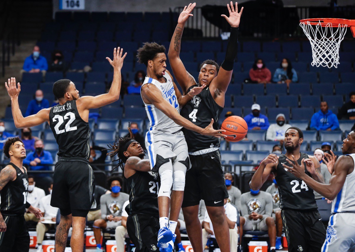 <strong>Tigers forward DeAndre Williams (middle) makes a pass while driving the lane against UCF on Wednesday, Feb. 3, 2021.</strong> (Mark Weber/The Daily Memphian)