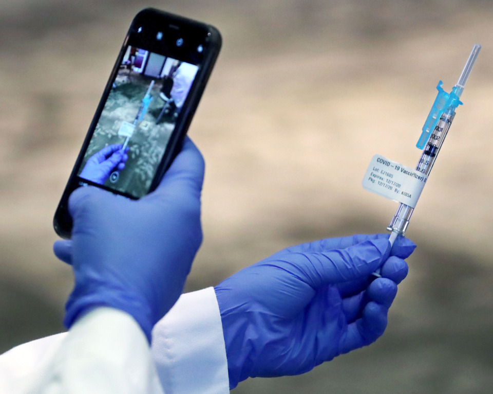 <strong>Sterling Torian takes a picture of one of the first COVID-19 vaccinations administered on Dec. 17, 2020.</strong> (Patrick Lantrip/Daily Memphian file)