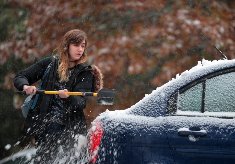 <strong>Averiel Hossley clears off her car in Overton Park as an early snow falls on Memphis in November 2018. More winter weather is headed to the Mid-South</strong>. (Jim Weber/Daily Memphian file)