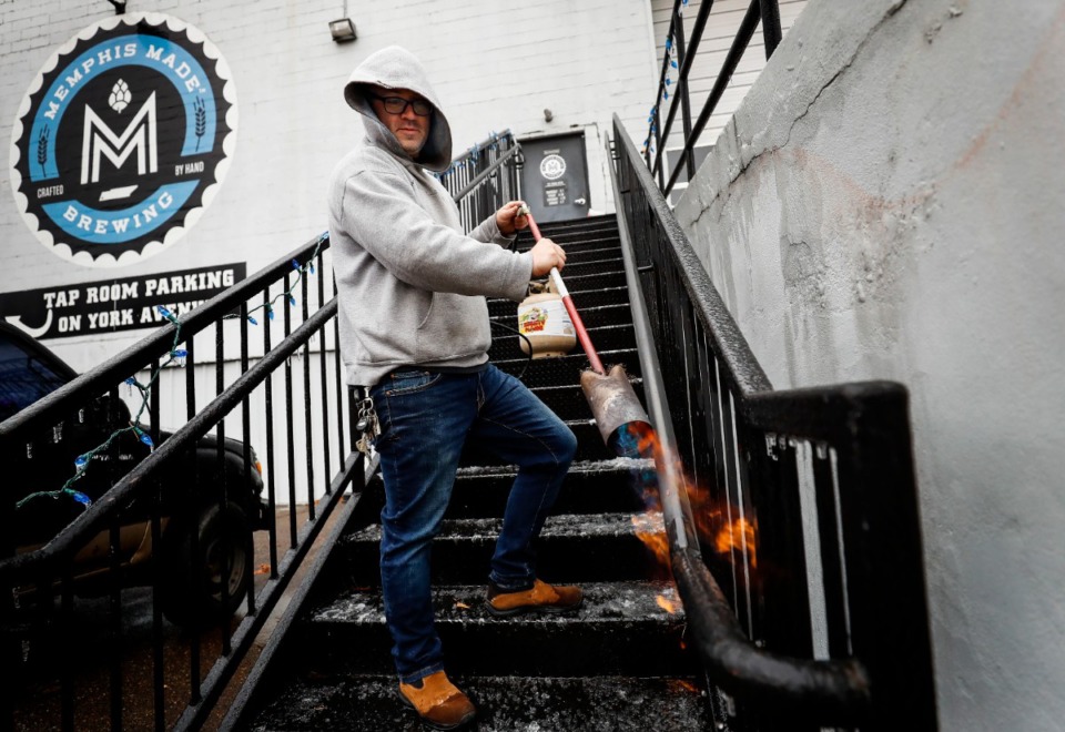 <strong>Drew Barton uses a propane torch to melt ice on handrails outside Memphis Made Brewing Co. on Thursday, Feb. 11. Freezing rain fell overnight&nbsp;in Memphis and Shelby County.</strong> (Mark Weber/Daily Memphian)