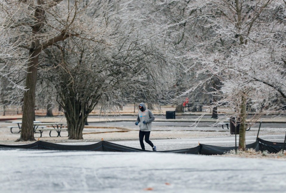 <strong>Surrounded by ice-covered trees, a runner makes his way through Overton Park on Thursday, Feb. 11, after freezing rain fell overnight&nbsp;in Memphis and Shelby County.</strong> (Mark Weber/Daily Memphian)