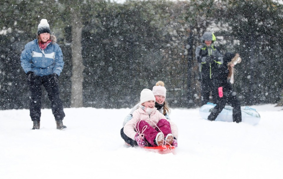 <strong>Evans Ragin, 12, (front) and Gemma Ferguson, 12, (back) slide down a hill during a heavy snow in Overton Park on Monday, Feb. 15, 2021.</strong> (Mark Weber/The Daily Memphian)