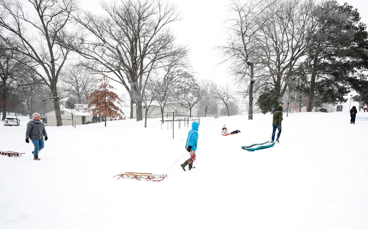 <strong>Sledders head up a hill during a heavy snow storm in Overton Park on Monday, Feb. 15, 2021.</strong> (Mark Weber/The Daily Memphian)