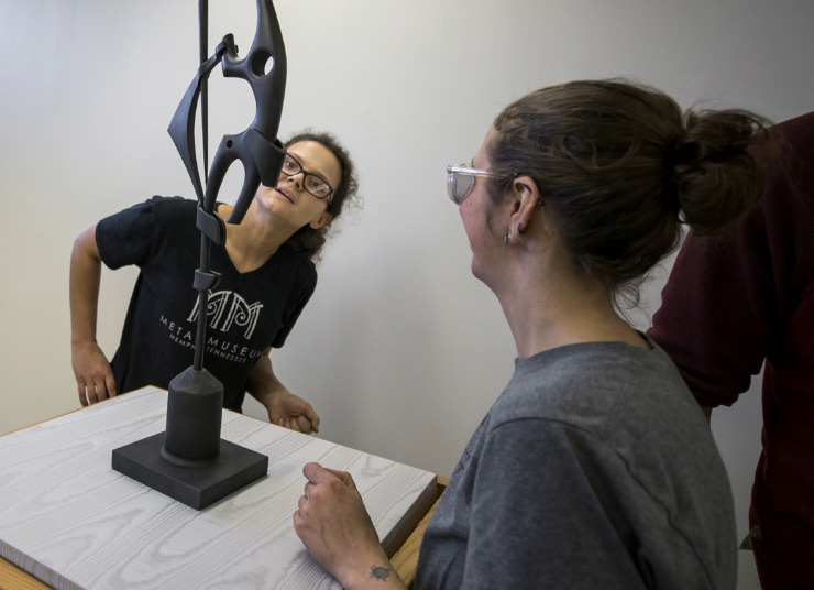 <strong>Metal Museum foundry apprentice Cassi Rebman inspects a sculpture being installed in the foyer of the Beverly &amp; Sam Ross Gallery at Christian Brothers University. This year's "Forge, Cast, Fabricate" exhibition features works by three Metal Museum apprentices and a half-dozen staff artists.</strong> (Houston Cofield/Daily Memphian)