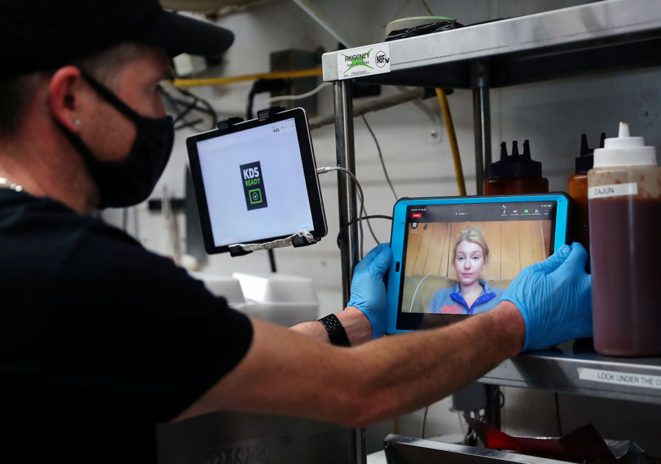<strong>Matthew Kersey talks with&nbsp;&ldquo;ninja&rdquo; Sydney Groom, a University of Florida grad student who takes orders remotely and relays them to Baby Jacks BBQ in Bartlett on Friday, Feb. 19, 2021.</strong> (Patrick Lantrip/Daily Memphian)