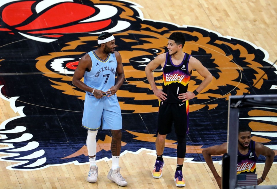 <strong>Memphis Grizzlies forward Justise Winslow (7) shares a laugh with Phoenix Suns guard Devin Booker (1) after checking into a Feb. 20, 2021 game at the FedExForum.</strong> (Patrick Lantrip/Daily Memphian)