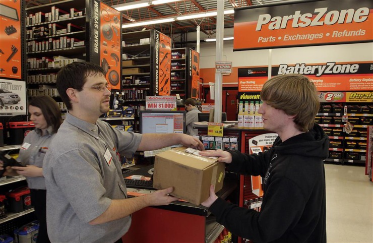 Autozone employee Timothy Spina, left, hands a part to customer Taylor House at the Autozone retail store at 7699 W. Farmington in Germantown.&nbsp;(Photo by Lance Murphey)