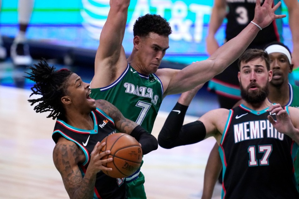 <strong>Memphis Grizzlies' Ja Morant (left), is fouled going to the basket by Dallas Mavericks' Dwight Powell (7) as center Grizzlies' Jonas Valanciunas (17) looks on in an NBA basketball game in Dallas, Monday, Feb. 22, 2021.</strong> (Tony Gutierrez/AP)